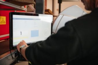 En man trycker på en digital skärm med WMS-mjukvara
